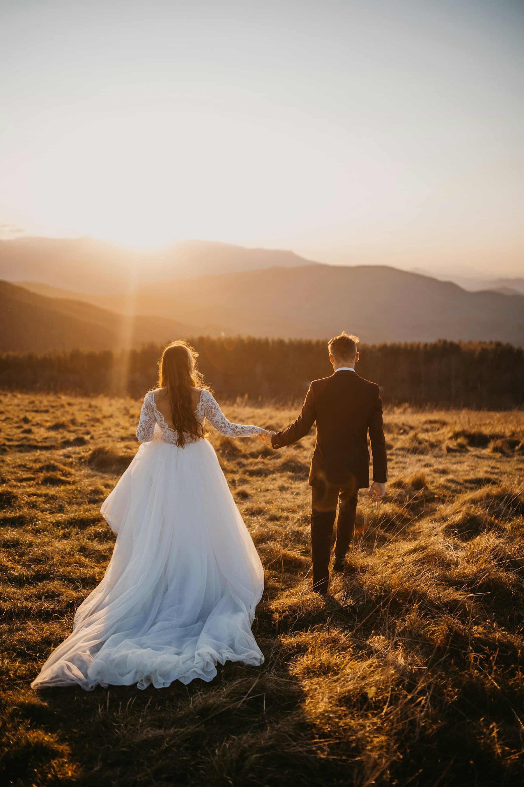 A couple walking through golden grass